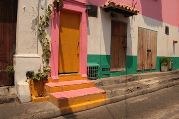 Stunning colonial architecture of Cartagena, Colombia’s historic old town, showcasing vibrant, brightly colored facades with intricate balconies adorned with lush flowers. The image captures the charm