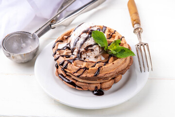Stack of chocolate waffles with ice cream and topping