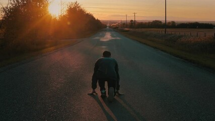Man Getting Ready to Run Down Long Road at Sunset
