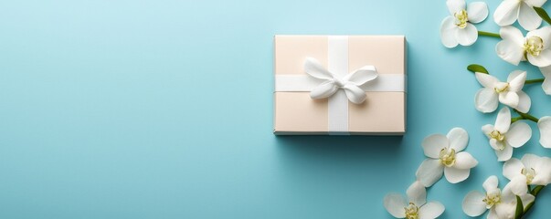 Gift box with ribbon and flowers, blue background.