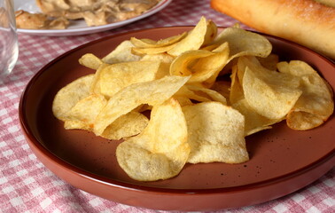 Potato chips arranged on a plate. Savory appetizers for an aperitif with friends.