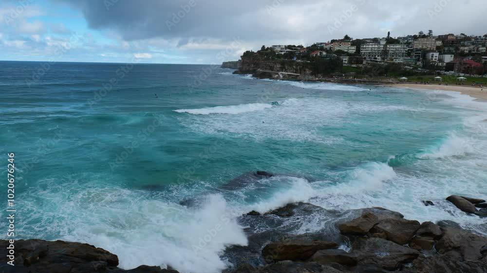 Poster powerful ocean waves crash against the shoreline of bronte beach, creating a mesmerizing display of 