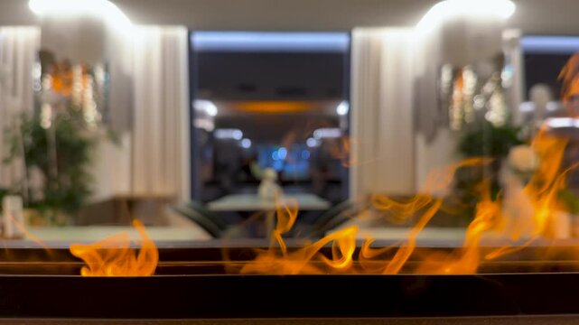 Close-up on bio fireplace burning inside restoran. Detail in interior, decorative fireplot at cozy modern hotel. Electric fireplace insert a stylish addition to any room. 