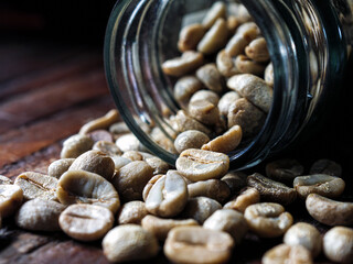 Green coffee beans poured out of a glass jar, Close-up of green raw coffee bean, unroasted coffee bean