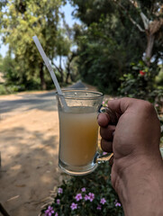 hand holding a glass of grapefruit juice
