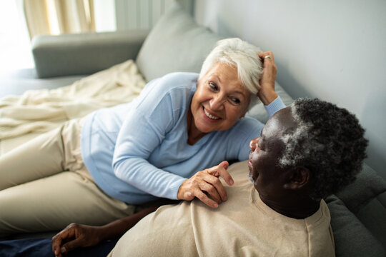 Diverse senior couple relaxing together on the couch at home