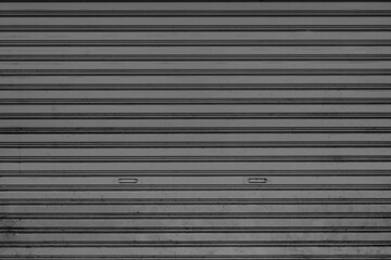 Obraz premium The surface of the dark gray rolling door was old and dusty.