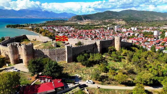 Aerial drone footage of Samuil's Fortress in Ohrid, with stunning views of the entire fortress, Lake Ohrid, and the sky with soft clouds. Perfect for projects featuring historical and natural landscap