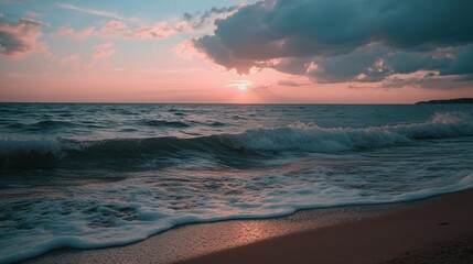 A wave rolling onto a sandy beach at sunset