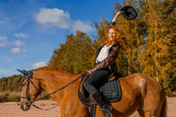 Stylish professional female jockey standing near horse. Friendship with horse. 