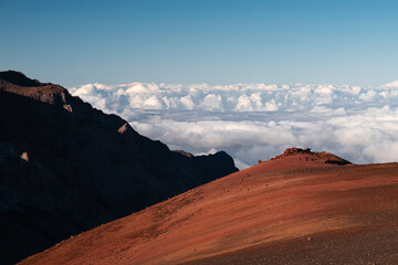 Fototapeta premium View of the volcano craters at Haleakala with spectacular clouds, blue sky and red dirt (Maui, Hawaii, USA)