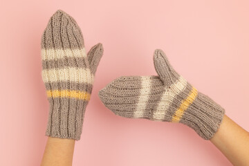 Knitted warm woolen mittens on the hands