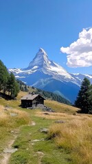 Fototapeta premium Scenic view of the Matterhorn mountain, surrounded by lush greenery and a charming wooden cabin, under a clear blue sky.