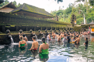 Praying in holy spring water of sacred pool at Pura Tirta Empul Temple, Tampaksiring, Bali, Indonesia