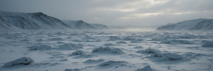 Obraz premium A large, snowy field with a few rocks scattered throughout. The sky is cloudy and the sun is setting