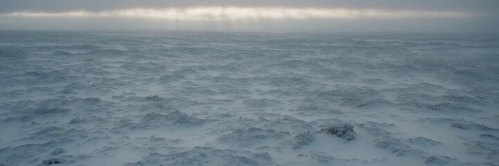 Fototapeta premium A large body of water is covered in snow. The snow is white and the water is blue