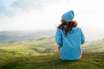 serene moment of reflection on hilltop overlooking lush green valleys at sunset