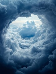 Naklejka premium A captivating view of the sky through swirling clouds at twilight, revealing a glimpse of light above the stormy atmosphere