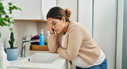 Woman with Headache Leaning on Bathroom Sink