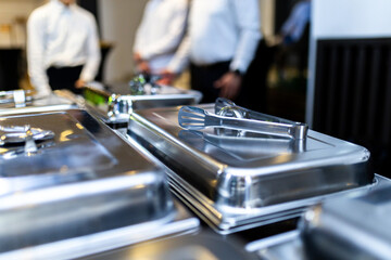 Catered buffet setup featuring metallic serving trays at a formal event in an elegant venue during the evening