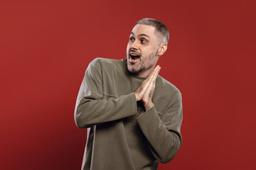 man with a happy expression, standing with his hands together