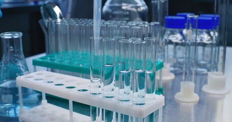 Scientist in medical laboratory fills test tubes with liquid of developed sample for research....