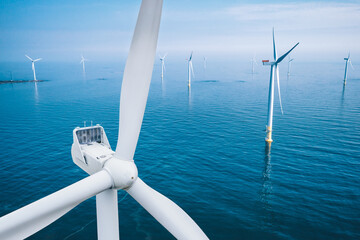 Wind turbine close-up. Aerial view of wind turbines or windmills farm field in blue sea in Finland. Alternative energy.