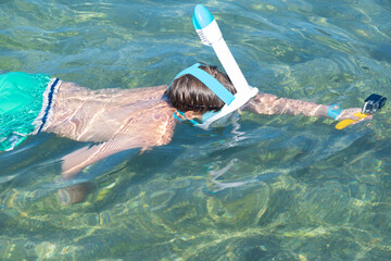 child enjoying snorkeling in sea water, filming fish with underwater camera, enjoying active summer...