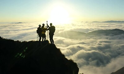 Hikers Celebrate on Mountain Peak at Sunrise
