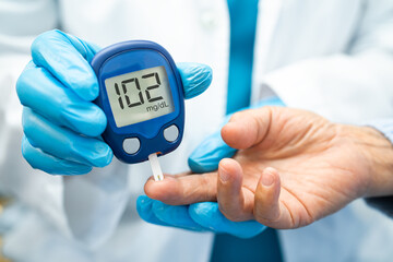 Doctor check diabetes from finger blood sugar level with finger lancet.