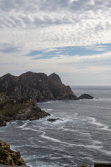 Image Description: Dramatic coastal landscape with rugged cliffs, crashing waves, and a cloudy sky....