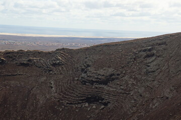 desertic landscape of volcano and caldera on the sea side