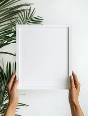 Close up of white wooden frame in female hands, poster mockup, blank interior painting template