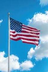 Obraz premium Large American flag waving high in the clear blue sky