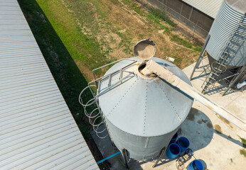 Feed truck delivering feed to the storage bins of chicken houses..