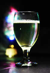 wine glass with some colored bokeh background and dark areas can be used as wallpaper or illustration image