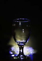 wine glass with some colored bokeh background and dark areas can be used as wallpaper or illustration image