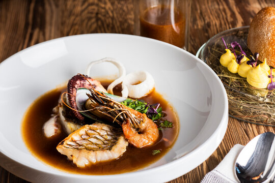 Leckere Bouillabaisse auf rustikalem Holztisch