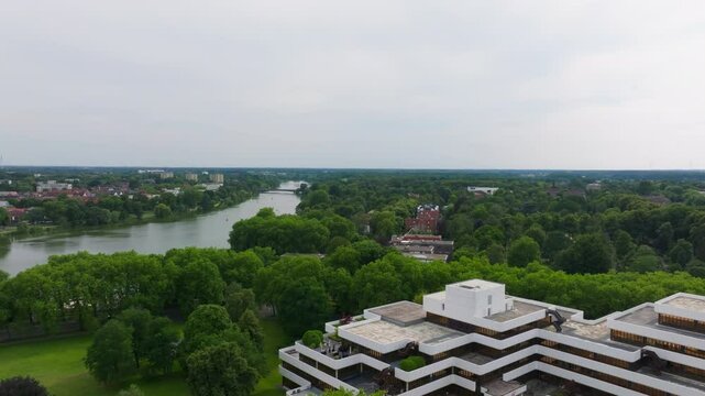 Aerial view of the city of Munster, germany. The camera pans over the city, showing the Aasee Lake and the surrounding green trees