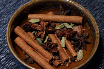 Cinnamon sticks, star anise, cardamom and cloves in a bowl