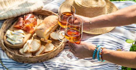Wine in hands of woman at picnic. Selective focus.