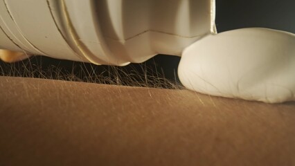 Macro shot of skin and hair texture. Shaving foam is applied thickly to the hand. Dark studio with...