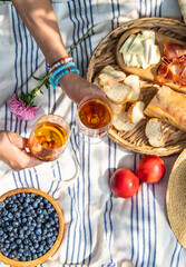 Wine in hands of woman at picnic. Selective focus.