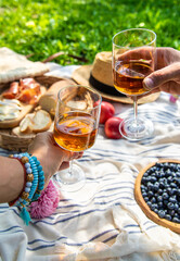 Wine in hands of woman at picnic. Selective focus.