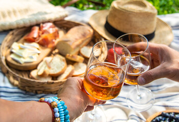 Wine in hands of woman at picnic. Selective focus.