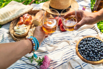 Wine in hands of woman at picnic. Selective focus.