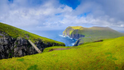 Asmundarstakkur, Faroe Islands, Denmark. Panoramic view of the pasture, ocean bay and the...