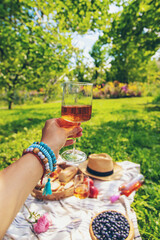Wine in hands of woman at picnic. Selective focus.