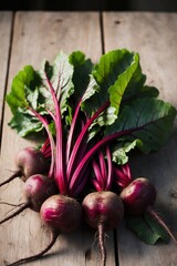 Fresh beetroots with greens on rustic wooden table in natural light.