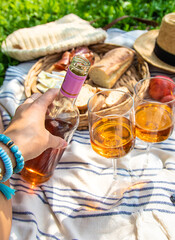 Wine in hands of woman at picnic. Selective focus.